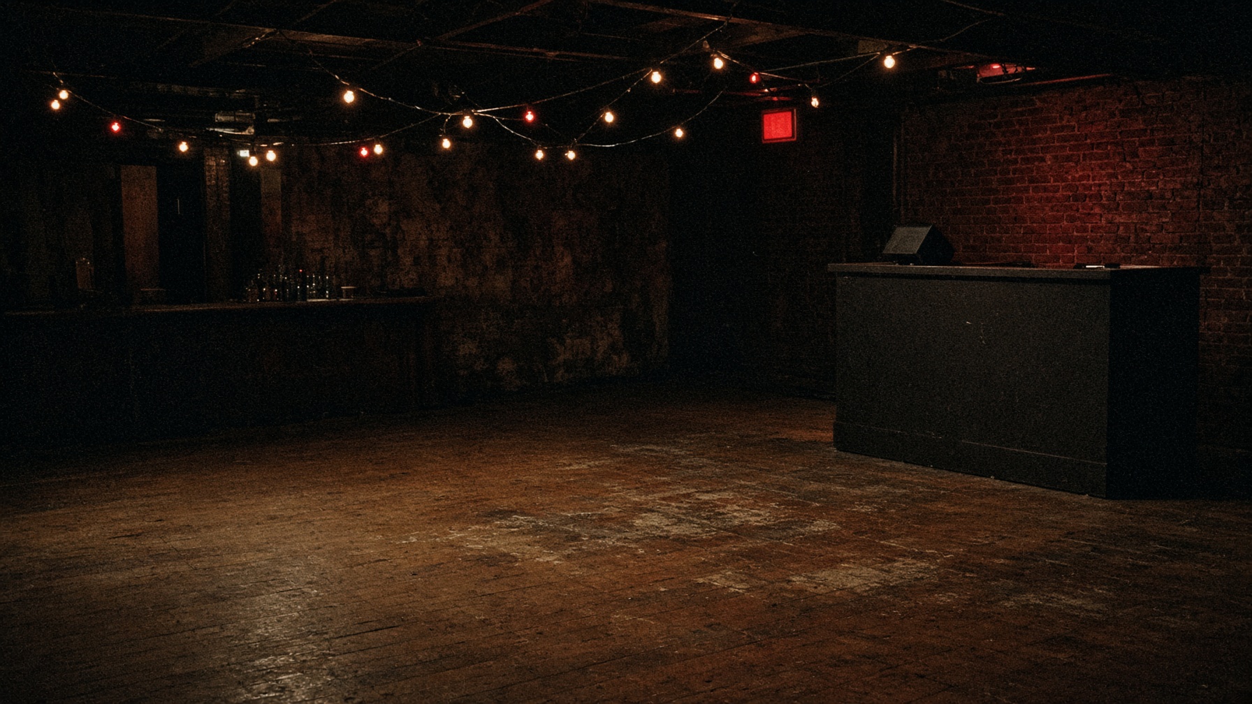An empty basement venue, lights on, nobody in yet.